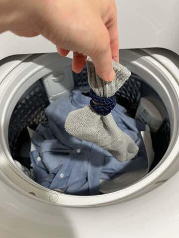 靴下を洗濯機に入れるところ